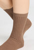 Back view of a women model wearing HA canyon brown wool Socks
